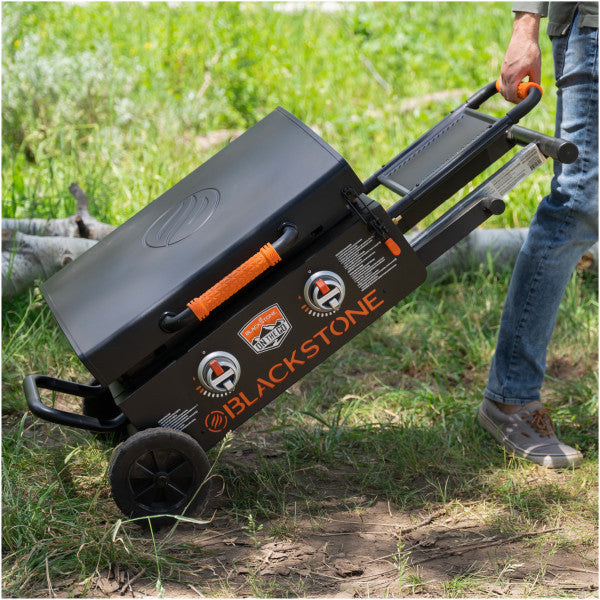 Hombre transporta plancha Blackstone portátil con soporte plegable para asados y bbq