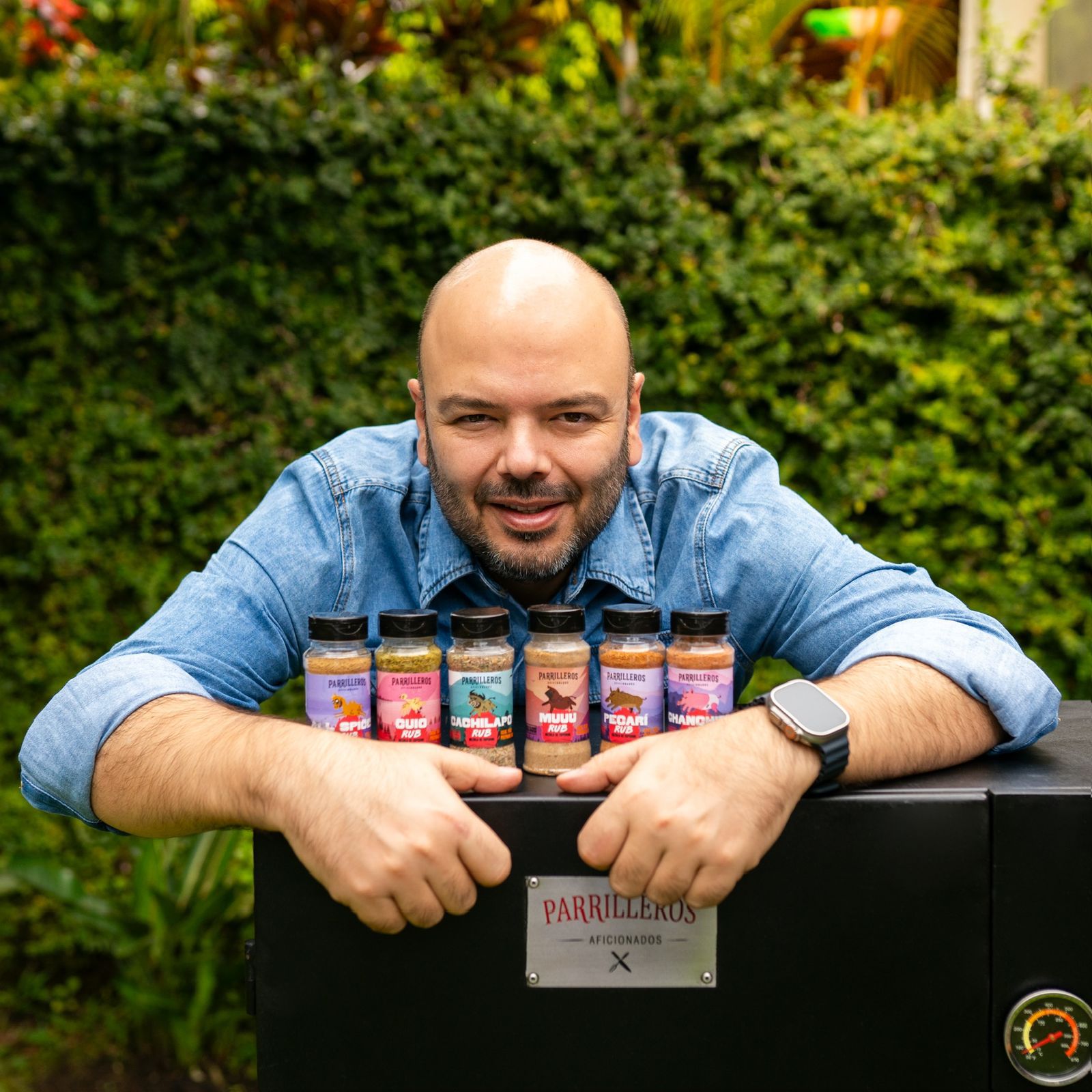 Hombre sosteniendo varios sazonadores para carne, ideal para asados, parrilla y bbq.