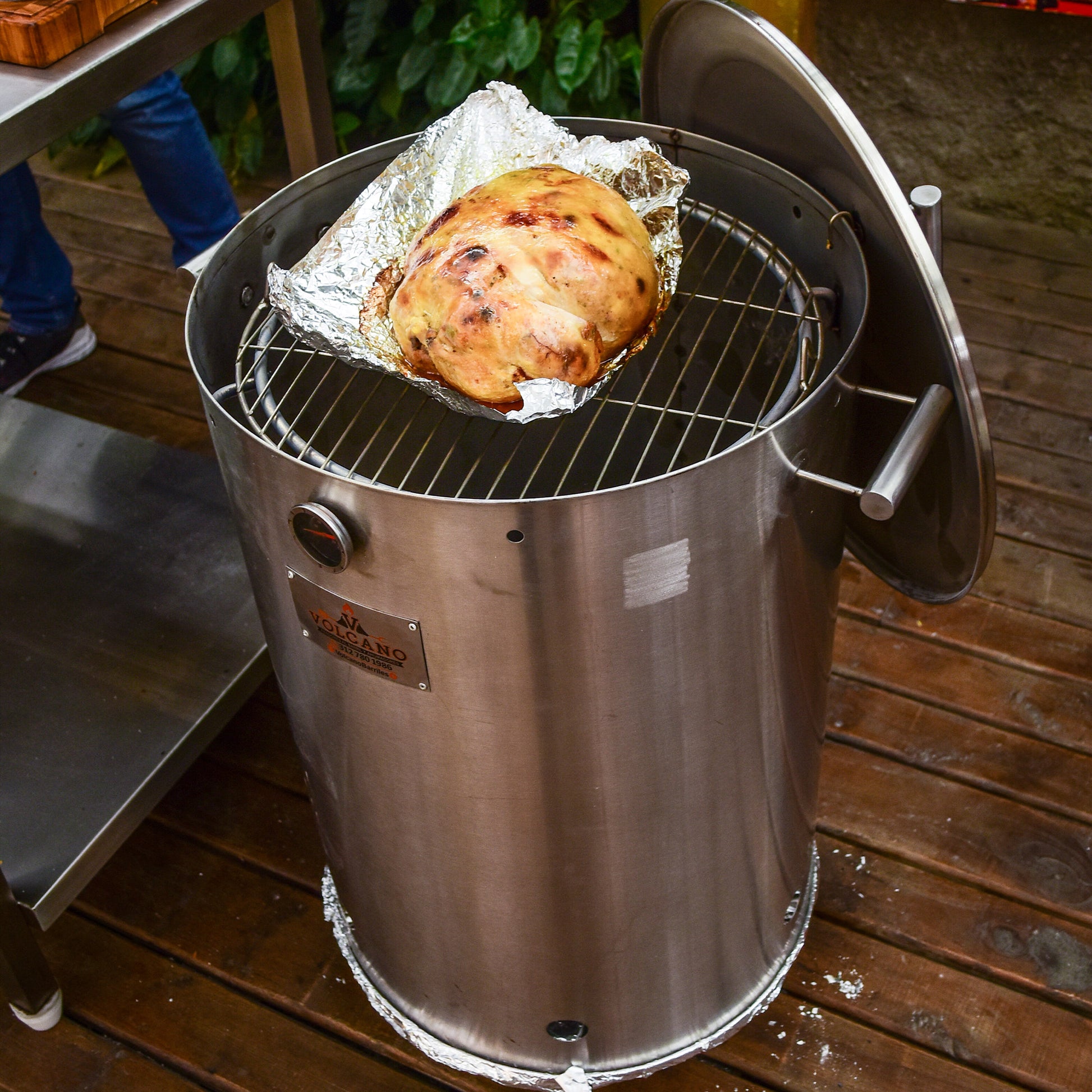 Barril asador de acero inoxidable con pollo rostizado, ideal para asados, parrilla y ahumados